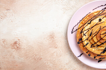 Half shot of Classic American homemade pancakes decorated with chocolate syrup on a white background