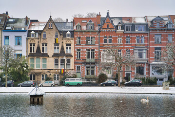 Winter Brussels, snow-covered houses. City landscape with lake in winter, Belgium