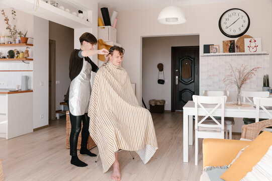 Female barber working with client at home