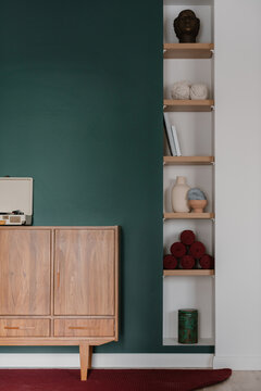 Wooden cabinet and shelves with vases in retro interior