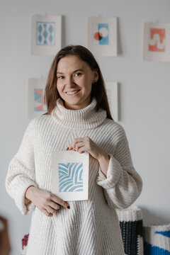 Smiling artist showing hand drawn abstract sketch