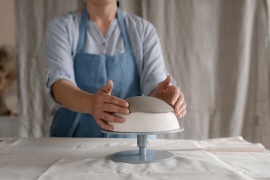 Female ceramist molding clay in modern workshop