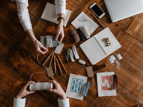 Faceless artists creating samples of woven rug ornaments