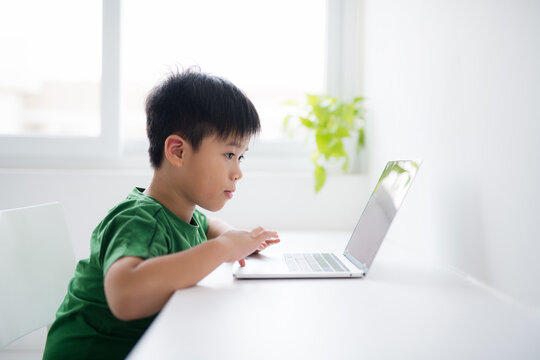 Young boy working on laptop computer concept for education, learning, internet, homework and social media