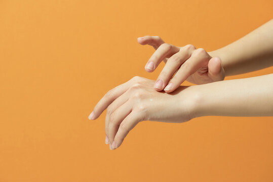 Young woman applies serum on her hands