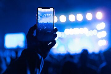 Silhouettes of concert crowd in front of bright stage lights