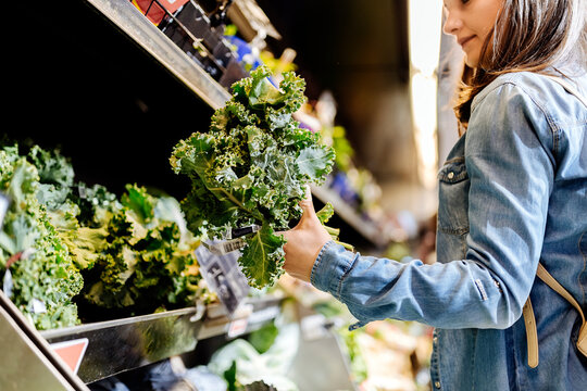 Beautiful woman taking a lettuce in supermarket.