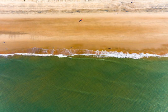 Aerial view of the ocean with the waves crashing onto the shore of Playa de Parador Mazag&oacute;n, Huelva, Spain.