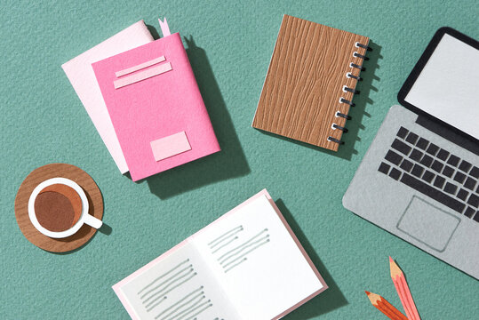 Office table with blank notepad and laptop