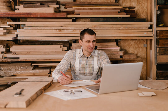 Male carpenter using laptop in workshop