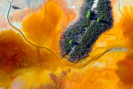 Aerial view of small green patch of terrain surrounded by brown acids of Rio Tinto Mines area