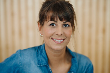 Close-up of female owner standing against wall in cafe