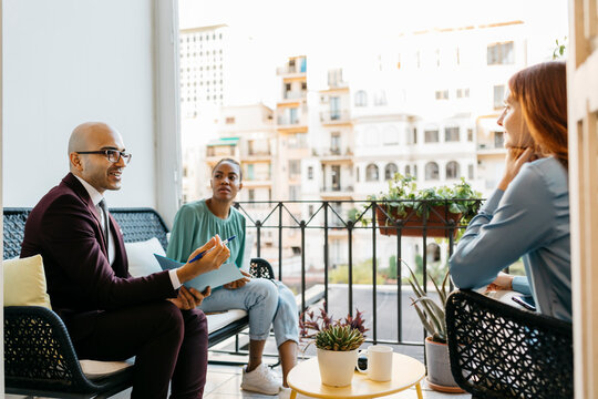 Coworkers discussing while planning business strategy in balcony