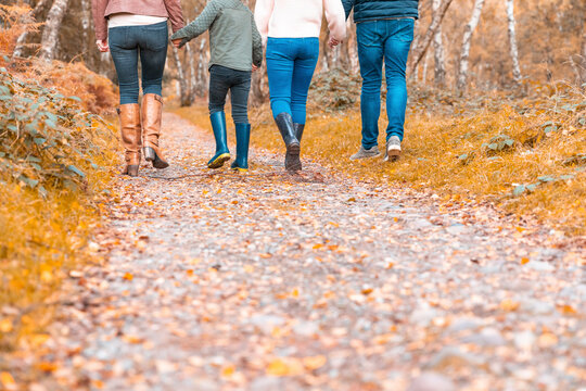 Low section of family walking in park during autumn