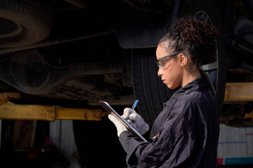 Young lady repairman Checking the condition of the car's tires at the tire shop.