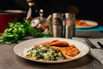Healthy diet meal.Creamed green vegetables with parmesan cheese and almond flour breaded chicken breast filets.Low carb recipe for a keto lifestyle.Ketogenic carb counting.Low carbohydrate vegetables