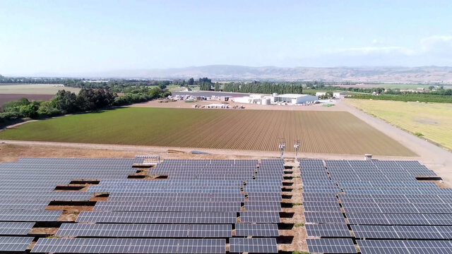 solar panels farm and agriculture fields in aerial view.