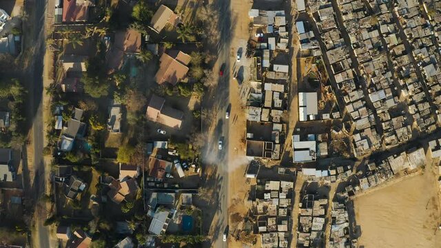 Inequality.Aerial close-up straight down view of an informal settlement Kya Sands squatter camp right next to middle class suburban housing, Gauteng Province, South Africa