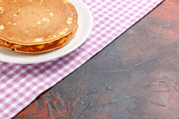 Half shot of delicious pancakes on a pink stripped towel on mixed color background
