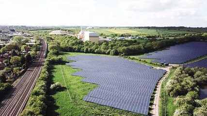 solar energy panels farm and the train railway and industrial factories and agriculture files from aerial view. - 399419726