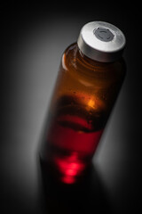 Macro Shot Of Amber Vaccine Vial In Black Background