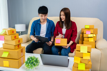 couple entrepreneur working and prepare parcel box for deliver to customer at home, (SME business)