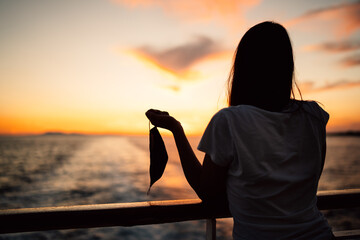 Concept of coronavirus free world.Woman taking the mask off.Safe travelling,nautical tourism.Life...