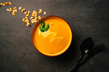 Served creamy bright orange butternut squash soup. Creamed blended yellow and orange vegetables,...