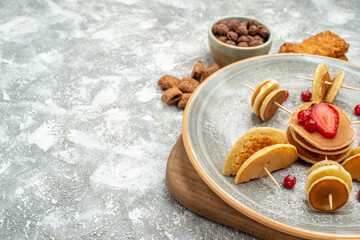 Close up view of homemade pancakes and biscuits on wooden cutting board on blue backgound