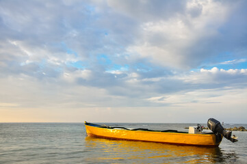 Fototapeta premium yellow boat at sunset on a calm sea