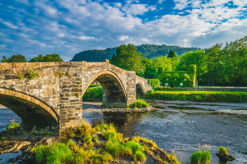 Fototapeta na wymiar Stone bridge in Llanrwst with old cottage covered with vine leaves. Snowdon, North Wales. UK