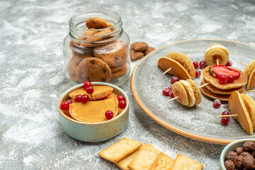Homemade pancakes cakes and chocolate biscuits in a glass jar on blue background