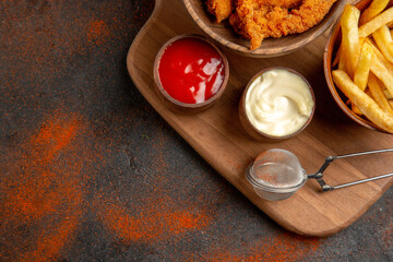 Half shot of tasty dinner with fried chicken and potatoes with mayonnaise on mixed color background