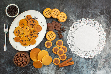 top view of different sorts of sweets and a piece of lace on grey ground