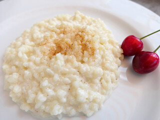 Rice Porridge Sprinkled With Cinnamon Sugar And Garnished With Two Cherries