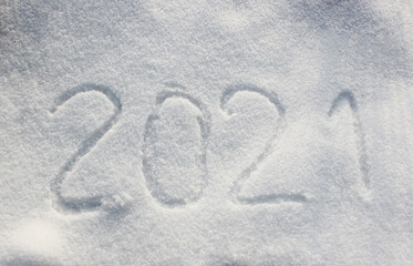 The inscription on the snow New 2021. Christmas Eve, winter day with snowfall. flying snowflakes. there are shiny winter snowdrifts on the ground, New Year's mood outside