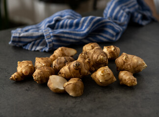 Close up of Fresh Jerusalem Artichokes on Dark Table