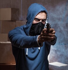 Aggressive manwith gun wearing face mask