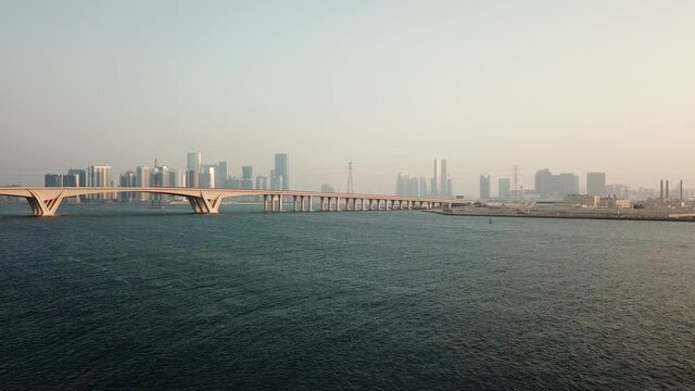 Aerial View of Abu Dhabi UAE, Bridge Over Persian Gulf Water and Misty Downtown in Skyline With Skyscrapers, Drone Shot