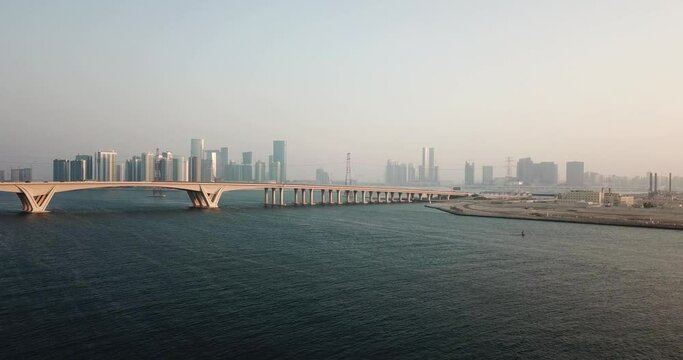 Aerial View of Abu Dhabi Cityscape Panorama From Saadiyat Island, Sheikh Khalifa Bridge and Skyscrapers in Mist, Drone Shot