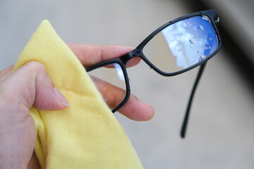 The white man's hands cleaned his glasses with a clean cloth.