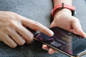 A woman using a smartphone checks the stock market . Concept of Technology and Investment