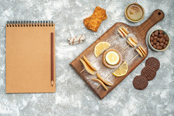 Classic pancakes with lemon on cutting board with cookies biscuits and notebook on blue backgrounds