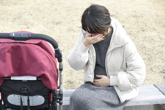 つわりに苦しむ妊婦　女性　人物　屋外