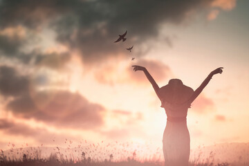 Silhouette woman with hands rise up on beautiful view. Christian praise on hill thanksgiving day...