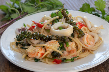 Spaghetti Thai style with fresh green pepper, squid and shrimps