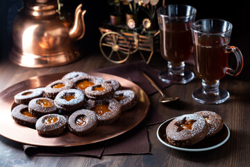 Chocolate Linzer cookies on a copper tray served with tea.