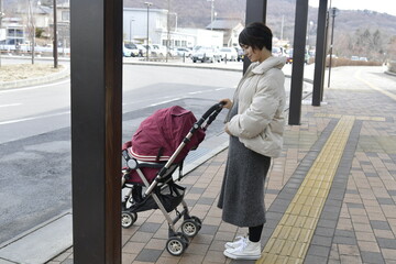バス停でバスを待つ妊婦の女性