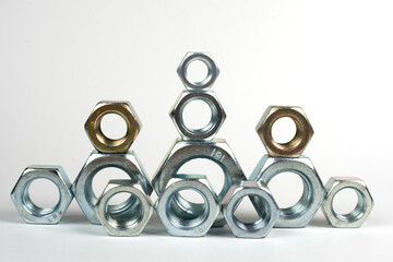 many metal nuts stacked on a white background