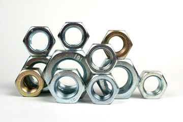 many metal nuts stacked on a white background